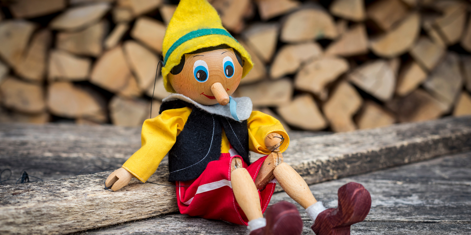 Pinocchio sitzt auf einem Holzbrett