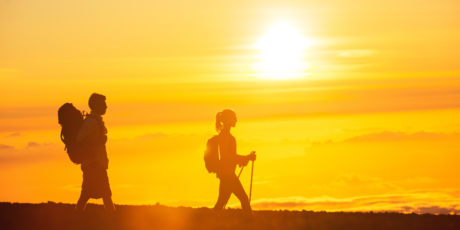 Meine Personen wandern. Im Hintergrund ist die Sonne, die das Foto in einen gelben Farbton taucht.