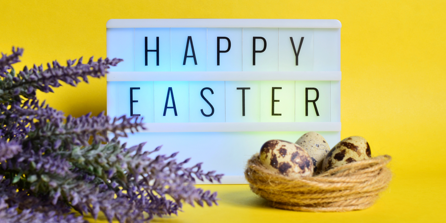 links ist ein Lavendelbüschel zu sehen, in der Mitte steht ein Schild mit der Aufschrift 'Happy Easter' und vor dem Schuld steht ein Nest mit Eiern