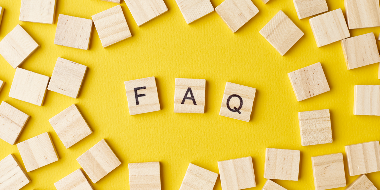 canva Auf dem Bild sind viele kleine Holzsteine/Scrabblesteine zu sehen. In der Mitte steht das Wort FAQ